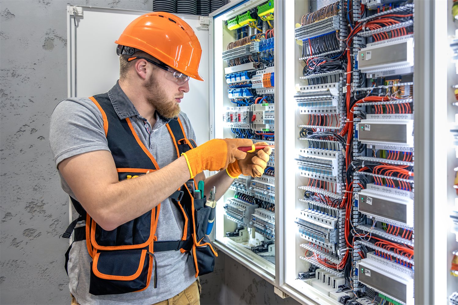 Tecnico al lavoro sulla manutenzione di un quadro elettrico